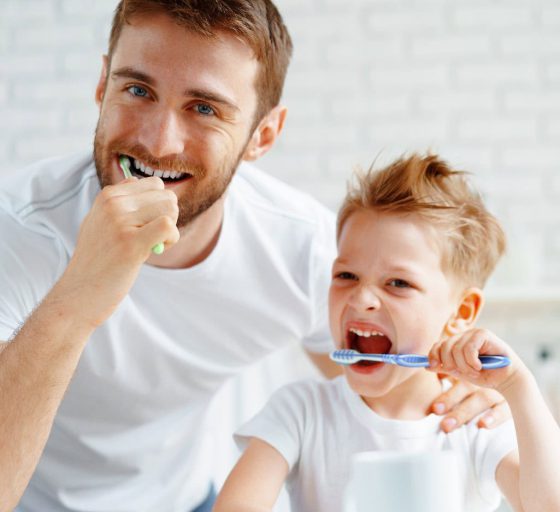 Papa und kleiner Sohn putzen gemeinsam Zähne